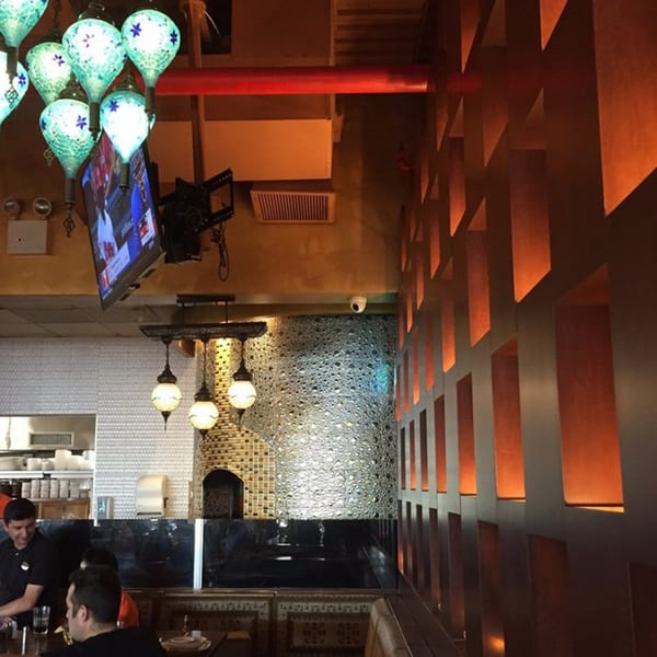 Interior of Opera Cafe Lounge with Turkish lamps, a decorative wall, and patrons dining.