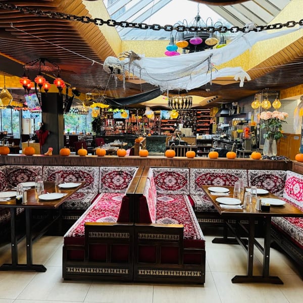 Opera Cafe Lounge interior with Turkish-style seating, Halloween decorations, and a bar in the background.