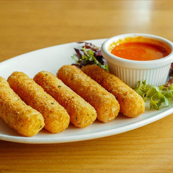 Five golden-brown mozzarella sticks with a side of red dipping sauce and green garnish on a white plate.