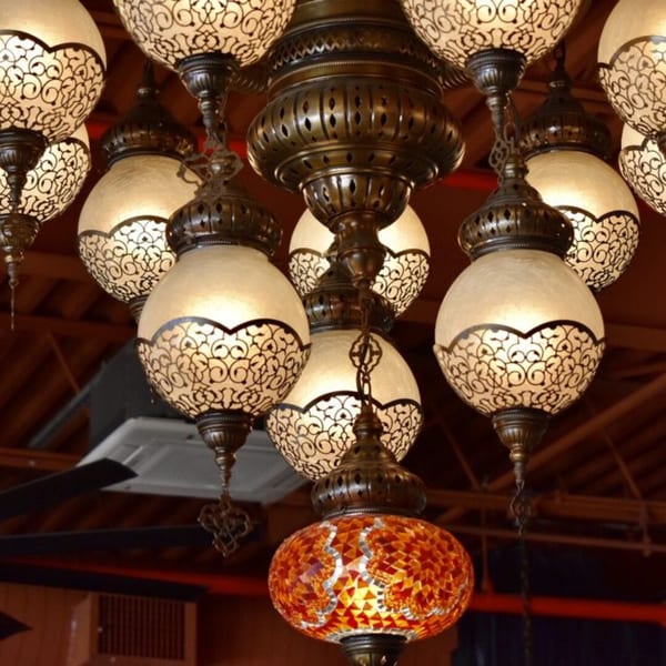 Ornate Turkish chandeliers with white and orange mosaic glass shades illuminate the restaurant interior.