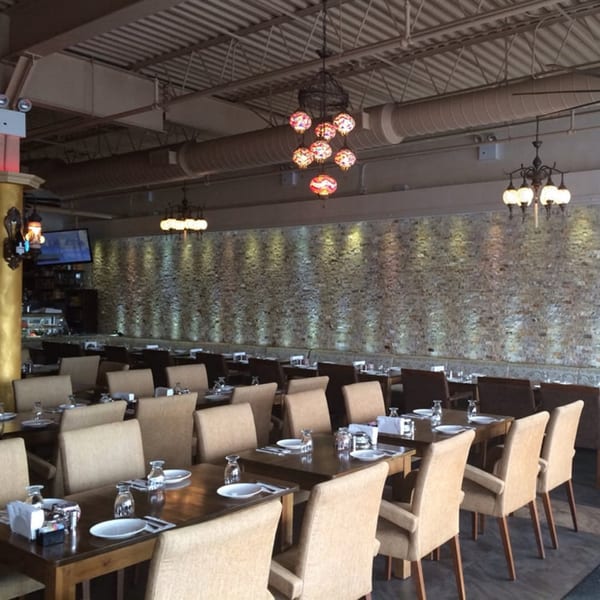 Opera Cafe Lounge dining room with set tables, upholstered chairs, and Turkish-style chandeliers.