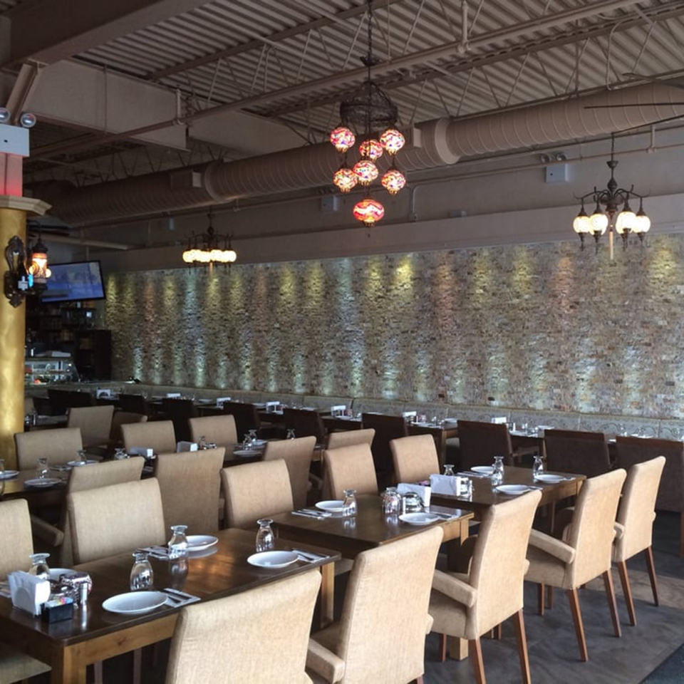 Opera Cafe Lounge dining room with set tables, upholstered chairs, and Turkish-style chandeliers.